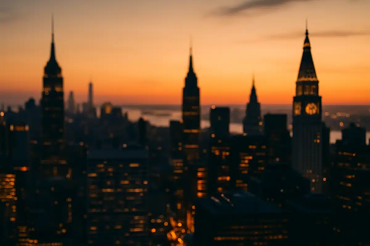 ```json { "altText": "Skyline de New York au coucher du soleil avec tour d'horloge symbolisant l'heure New York en temps réel", "caption": "Vue aérienne de Manhattan au crépuscule, illustrant le rythme urbain et le passage du temps dans la ville qui ne dort jamais.", "description": "Panorama spectaculaire de New York City à l'heure dorée, mettant en valeur les gratte-ciels emblématiques et une tour d'horloge en silhouette. Cette image illustre parfaitement le concept de l'heure New York en temps réel et le dynamisme constant de la métropole américaine, idéale pour comprendre les décalages horaires et fuseaux horaires de NYC." } ```